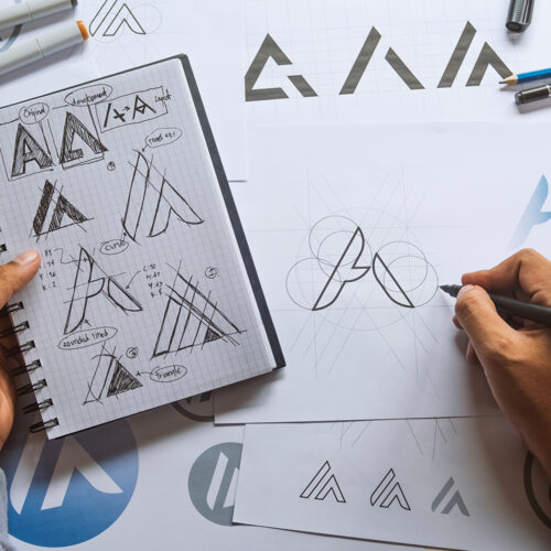 Hand-drawn logo design sketches on paper