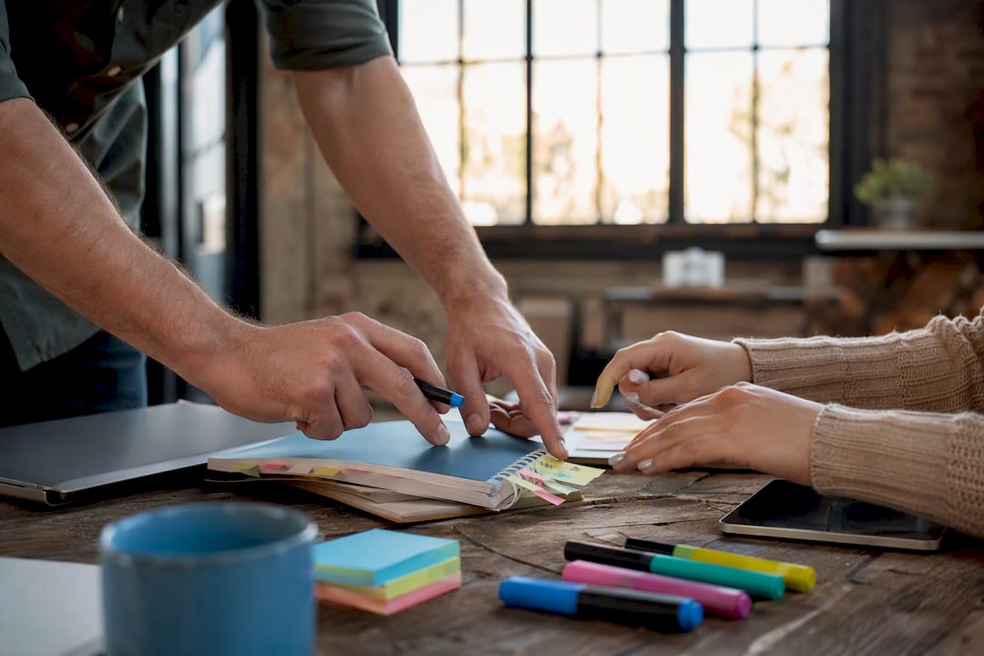 Hands arranging marketing schedules and tools