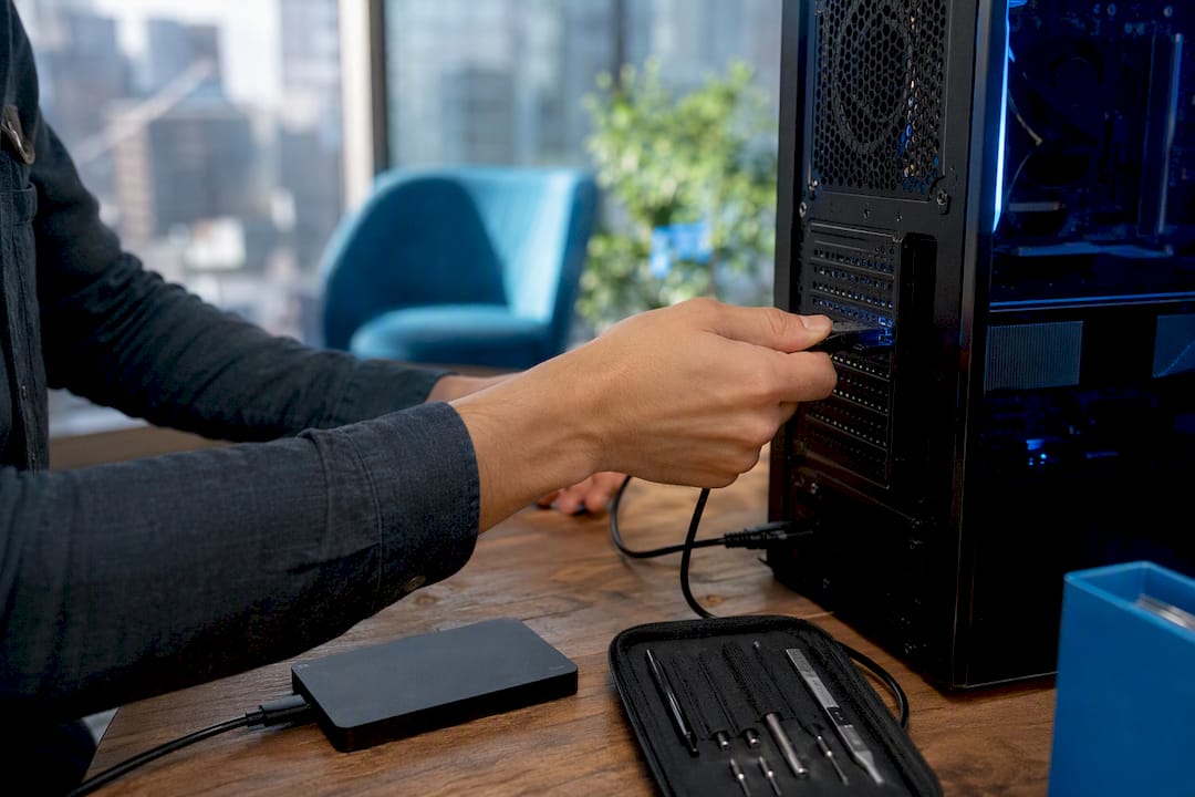 Hands unplugging cable from computer tower for optimization