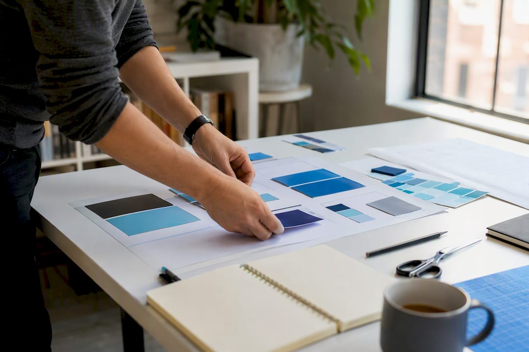 Hands arranging brand style guide materials