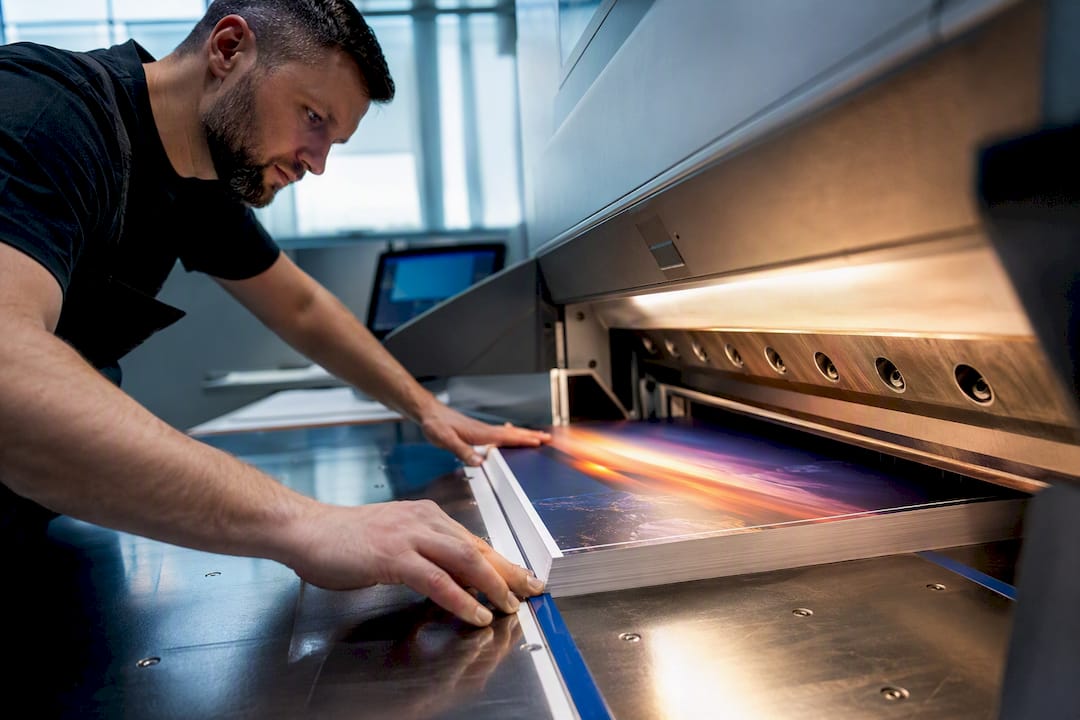 Operator aligning printed sheet for trimming